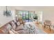 Inviting living room with a large sofa, chair, glass table, sliding doors to the lanai, and a TV at 14130 Rosemary Ln # 4115, Largo, FL 33774