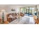 Comfortable living room showcasing a brown sofa, recliner, glass coffee table, and sliding doors to the lanai at 14130 Rosemary Ln # 4115, Largo, FL 33774