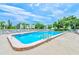 Community pool with surrounding lounge area and views of nearby buildings and sky at 14130 Rosemary Ln # 4115, Largo, FL 33774