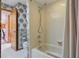 Tiled bathtub with shower, floral wallpaper and tile floor in this full bathroom at 14168 Fennsbury Dr, Tampa, FL 33624