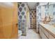 Traditional bathroom with floral wallpaper, single vanity, bathtub with shower, and tile floor at 14168 Fennsbury Dr, Tampa, FL 33624