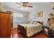 Cozy bedroom with wood floors, floral bedding, a ceiling fan, and good natural light at 14168 Fennsbury Dr, Tampa, FL 33624