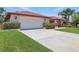 Charming single-story home featuring an attached two-car garage, red roof, and manicured landscaping at 14168 Fennsbury Dr, Tampa, FL 33624