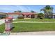 Inviting home with a lush lawn, manicured shrubbery, palm trees, and a quaint mailbox at 14168 Fennsbury Dr, Tampa, FL 33624