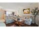 Cozy living room with hardwood floors, floral sofas, and an open view into the dining area at 14168 Fennsbury Dr, Tampa, FL 33624