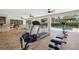 Bright patio area with exercise equipment, tile flooring and outdoor furniture overlooking the pool at 14168 Fennsbury Dr, Tampa, FL 33624