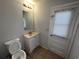 Bathroom with vanity and sink, updated mirror, light fixture, tile flooring and an exterior door at 14667 Pine Glen Crk # 14667, Lutz, FL 33559