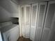 Laundry area includes a white washing machine and four panel folding doors at 14667 Pine Glen Crk # 14667, Lutz, FL 33559