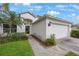 Front exterior shot highlighting the front entry, landscaping, and attached two-car garage at 15006 Shaw Rd, Tampa, FL 33625