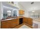 An open kitchen with light-colored wood cabinets and black appliances at 15006 Shaw Rd, Tampa, FL 33625