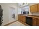Well-lit kitchen with wood cabinets, a pass-through to the dining area, and black appliances at 15006 Shaw Rd, Tampa, FL 33625