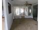 Empty living room with peeling walls, window, ceiling fan and open doorway to adjacent room at 1785 42Nd S St, St Petersburg, FL 33711