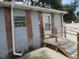 Rear exterior of home with small porch, brick facade, white rain gutters, and small, square window at 1785 42Nd S St, St Petersburg, FL 33711
