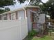 Side exterior of home with brick facade, newer vinyl fencing, exterior door, and green foliage at 1785 42Nd S St, St Petersburg, FL 33711