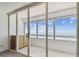 Balcony with ocean views featuring glass sliding doors, tiled floor, and small cabinet at 17900 Gulf Blvd # 16C, Redington Shores, FL 33708