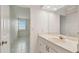 Bathroom featuring a sink with a light-up mirror and a peek into the tile-floored bedroom at 17900 Gulf Blvd # 16C, Redington Shores, FL 33708