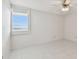 Sunlit bedroom showcasing tiled flooring, a window with blinds, and a ceiling fan at 17900 Gulf Blvd # 16C, Redington Shores, FL 33708