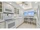 Eat-in kitchen features white appliances and an area with chairs overlooking a beautiful view at 17900 Gulf Blvd # 16C, Redington Shores, FL 33708