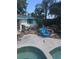 Spacious backyard featuring a pool, patio area, and lush landscaping at 1831 Pasadena Dr, Dunedin, FL 34698
