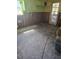 Bare kitchen area with damaged drywall, exposed studs, and concrete floors at 1831 Pasadena Dr, Dunedin, FL 34698