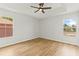 Bright bedroom featuring wood-look floors, a modern ceiling fan, and two windows at 2032 Sunset Meadow Dr, Clearwater, FL 33763