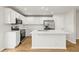 Modern white kitchen with quartz counters, stainless appliances, and hardwood floors at 2032 Sunset Meadow Dr, Clearwater, FL 33763