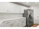 Contemporary kitchen featuring stainless steel refrigerator, white cabinets, and quartz countertops at 2032 Sunset Meadow Dr, Clearwater, FL 33763