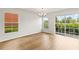 Bright living room with wood floors, large windows, and a sliding door offering natural light at 2032 Sunset Meadow Dr, Clearwater, FL 33763