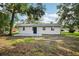 Wide shot of backyard showing rear exterior and tree coverage at 2220 3Rd E Ave, Bradenton, FL 34208