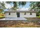 Backyard showcasing a home's rear exterior with fresh concrete, lawn and tree coverage at 2220 3Rd E Ave, Bradenton, FL 34208
