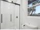 Bright bathroom showcasing a glass-enclosed shower with modern fixtures and a window view at 2220 3Rd E Ave, Bradenton, FL 34208