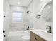 Bathroom featuring marble tiled walls, shower/tub and modern wood-look vanity at 2220 3Rd E Ave, Bradenton, FL 34208