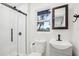 Modern bathroom features a glass shower door, sleek vanity, and window for natural light at 2220 3Rd E Ave, Bradenton, FL 34208