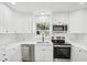 Bright kitchen with white cabinets, stainless steel appliances, and marble-look countertops at 2220 3Rd E Ave, Bradenton, FL 34208