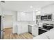 Well-lit kitchen featuring white cabinets, stainless steel appliances, and stone countertops at 2220 3Rd E Ave, Bradenton, FL 34208