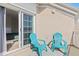 Inviting balcony area featuring sliding glass doors, blue chairs and an outdoor rug at 230 Columbia Dr, Tampa, FL 33606