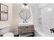 Updated bathroom features a modern vanity, round mirror, and tub with tiled surround at 230 Columbia Dr, Tampa, FL 33606