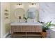 Bathroom featuring a double vanity with gold accents, modern lighting, and beautiful mirrors at 230 Columbia Dr, Tampa, FL 33606