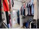 Walk-in closet with mirror leading to the light-filled bathroom and organized storage at 230 Columbia Dr, Tampa, FL 33606