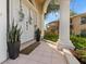 Charming front porch with tiled floor, decorative plants, and a pillar supporting an arched entryway at 230 Columbia Dr, Tampa, FL 33606