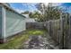 Green house and backyard with wooden fence, lush grass, and a shaded, covered patio area at 2320 E 12Th Ave, Tampa, FL 33605