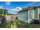 Backyard featuring a green house, wooden fence, lush grass, and shaded patio area at 2320 E 12Th Ave, Tampa, FL 33605
