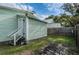 Backyard with green house with white trim, wooden fence, and partially covered ground at 2320 E 12Th Ave, Tampa, FL 33605