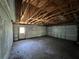 Spacious garage featuring exposed wooden beams and a large roll-up door at 2402 E 148Th Ave, Lutz, FL 33549