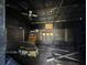 An unfinished, fire-damaged room with wooden shelves, a ceiling fan, and discarded boxes shows charring at 2402 E 148Th Ave, Lutz, FL 33549