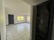 View of the living room showing the tile floor, exterior windows and doorway at 2402 E 148Th Ave, Lutz, FL 33549