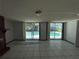 Living room with tile flooring, sliding glass doors overlooking a pool, and natural light at 2402 E 148Th Ave, Lutz, FL 33549