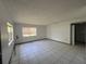 Bright living room with tiled floor, large window, and neutral walls at 2402 E 148Th Ave, Lutz, FL 33549