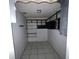 View of small pantry room with shelving, tile floors and a light fixture at 2402 E 148Th Ave, Lutz, FL 33549