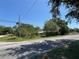 Street corner view of property showing foliage and home in the background at 2402 E 148Th Ave, Lutz, FL 33549